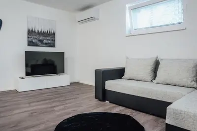 a living room with a couch and a television at Palace Garden in Ljubljana