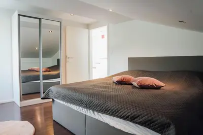 a bedroom with a bed with two pillows and a mirror at Palace Garden in Ljubljana