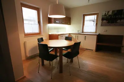 a kitchen with a table and chairs in a room at Apartment Na Krki in Kostanjevica na Krki