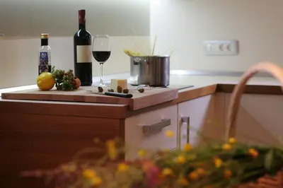 a kitchen with a bottle of wine and a wine glass at Apartment Na Krki in Kostanjevica na Krki