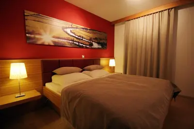 a bedroom with a bed and a painting on the wall at Apartment Na Krki in Kostanjevica na Krki