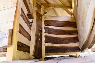 a wooden attic with a shower in a room at Adrenaline Check Camping in Bovec