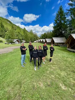 a group of people walking in a field at Adrenaline Check Camping in Bovec