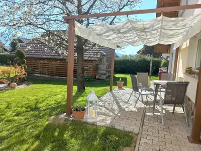 a patio with a table and chairs in a yard at Apartment Joga in Rečica ob Savinji