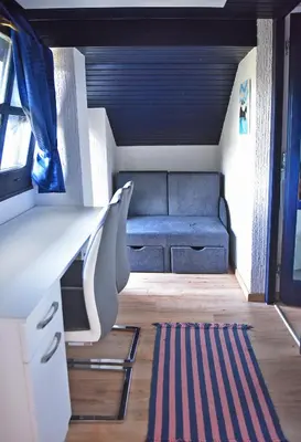 a living room with a blue couch and a rug at Salvus Apartma - Sun & Moon in Lendava