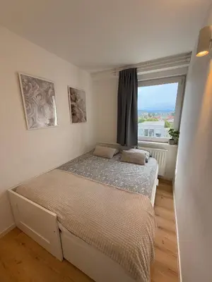 a bedroom with a bed and a large window at Central Elite Vista-with parking in Ljubljana