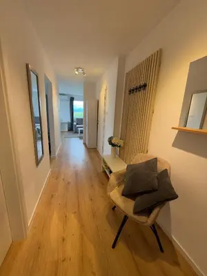 a living room with a chair and a hallway at Central Elite Vista-with parking in Ljubljana