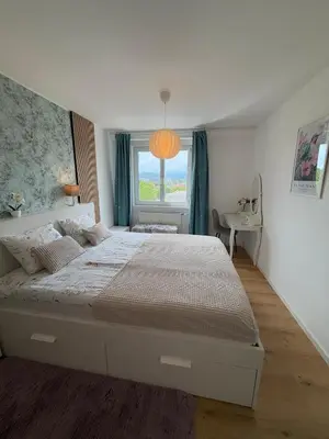 a bedroom with a large bed and a window at Central Elite Vista-with parking in Ljubljana
