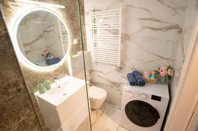 a bathroom with a sink and a washing machine at Central Elite Vista-with parking in Ljubljana