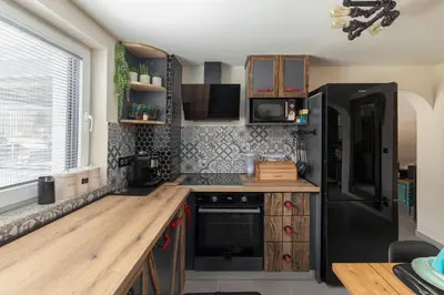 a kitchen with a black refrigerator and wooden cabinets at Deluxe House Maj in Brežice