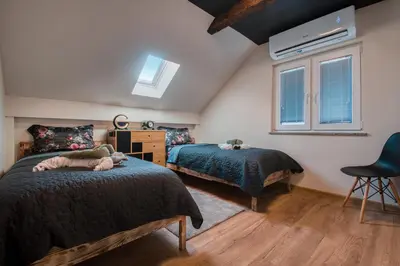 a bedroom with two beds and a window at Deluxe House Maj in Brežice