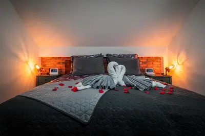 a bedroom with a bed with red roses on it at Deluxe House Maj in Brežice