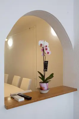 a flower in a vase on a shelf in a bedroom at Apartments Bells of Ljubljana - 3 cosy apartment Private Free Parking in Ljubljana