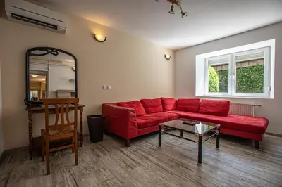 a living room with a red couch and a table at Apartments Bells of Ljubljana - 3 cosy apartment Private Free Parking in Ljubljana