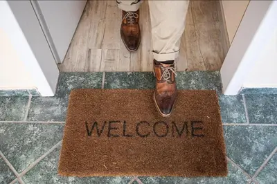 a person in brown shoes standing on a welcome mat at Apartments Bells of Ljubljana - 3 cosy apartment Private Free Parking in Ljubljana