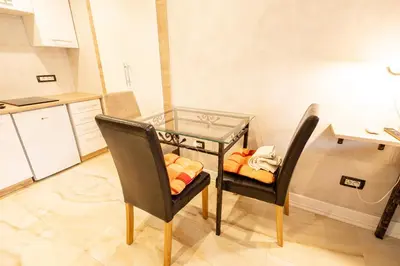a glass table and two chairs in a kitchen at Apartments Bells of Ljubljana - 3 cosy apartment Private Free Parking in Ljubljana