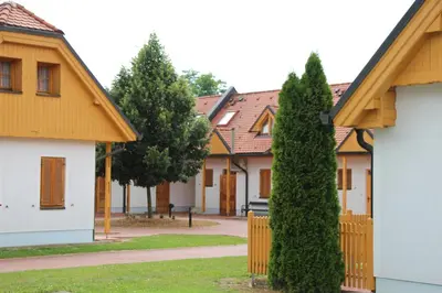 a row of houses with trees and a fence at Apartma Trobentica 15 in Moravske Toplice