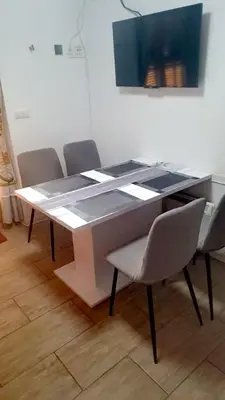 a dining room table with chairs and a painting on the wall at Apartma Trobentica 15 in Moravske Toplice