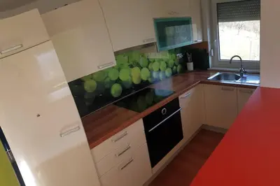 a kitchen with white cabinets and green balls on the wall at moderno opremljena hiša z odmaknjeno lokacijo in Dolenjske Toplice