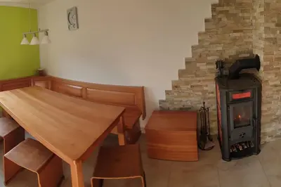 a room with a table and a wood stove at moderno opremljena hiša z odmaknjeno lokacijo in Dolenjske Toplice