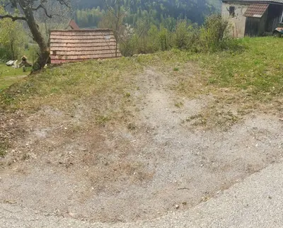 a dirt road in a field with a house at moderno opremljena hiša z odmaknjeno lokacijo in Dolenjske Toplice
