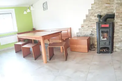 a room with a wooden table and a wood stove at moderno opremljena hiša z odmaknjeno lokacijo in Dolenjske Toplice