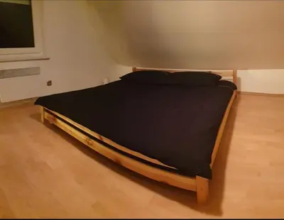 a bed in a room with a black mattress at moderno opremljena hiša z odmaknjeno lokacijo in Dolenjske Toplice