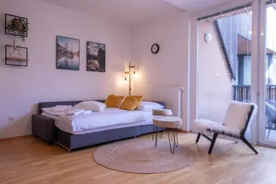 a bedroom with a bed and a table and a chair at Sunrise Bohinj Apartment in Bohinj