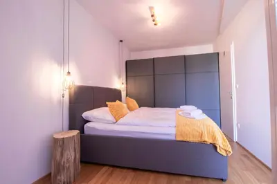 a bedroom with a bed with a large headboard at Sunrise Bohinj Apartment in Bohinj