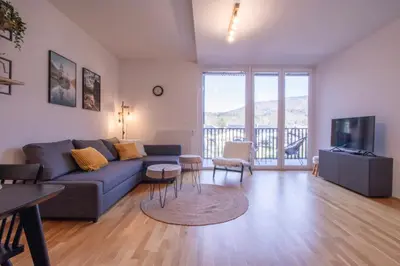 a living room with a blue couch and a tv at Sunrise Bohinj Apartment in Bohinj