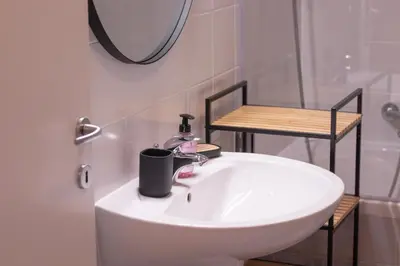 a white sink in a bathroom with a mirror at Sunrise Bohinj Apartment in Bohinj