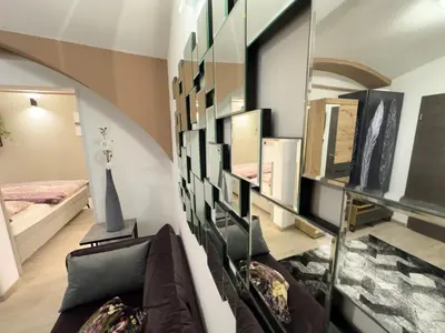a living room with a couch and a mirror at Apartments Adamas in Celje