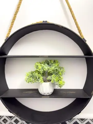 a black shelf with a potted plant on it at Apartments Adamas in Celje