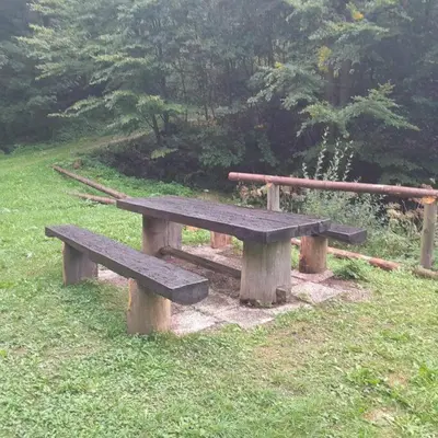 a wooden bench sitting in the grass in a field at Wooden Treasure in Jesenice
