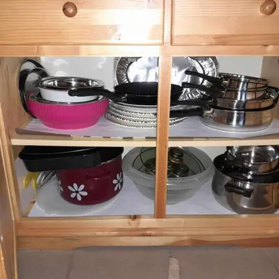 a cabinet filled with bowls and plates and pans at Wooden Treasure in Jesenice
