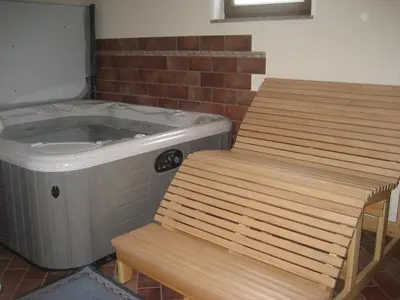 a bathroom with a tub and a table and a chair at Turistična kmetija Pri Rebkovih in Ajdovščina