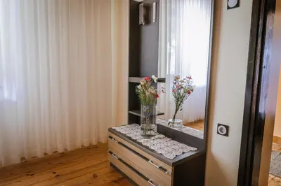 a dresser with a mirror and a vase of flowers on it at Apartment Skala with Magnificent view in Rečica ob Savinji