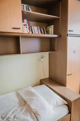 a bedroom with a bed and shelves with books at Apartment Skala with Magnificent view in Rečica ob Savinji