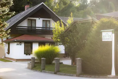 a white house with a sign in front of it at Studio Apartment Jož' in Spodnja Lipnica