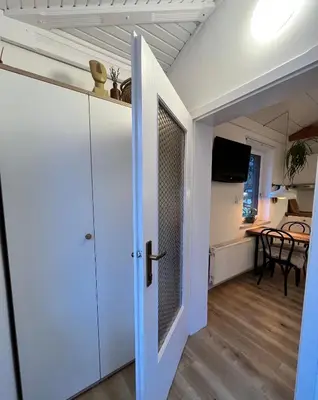 a room with a door and a dining room with a table at Studio Apartment Jož' in Spodnja Lipnica