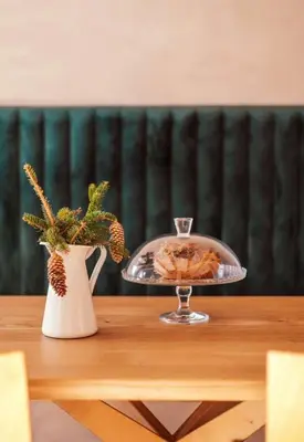 a tray of food on a wooden table with a vase at Apartment on the ski slope Pohorje 11 in Pohorje