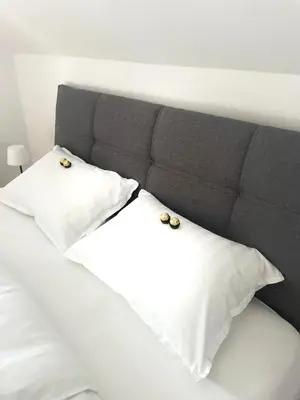 a bed with two white pillows with rings on them at Apartment on the ski slope Pohorje 11 in Pohorje
