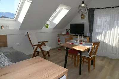 a living room with a table and a dining room at Apartments Ajda in Bohinj