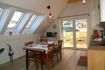 a kitchen and dining room with a table and chairs at Apartments Ajda in Bohinj