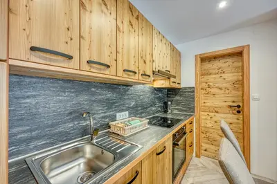 a kitchen with wooden cabinets and a sink at Apartments Viktor in Rateče