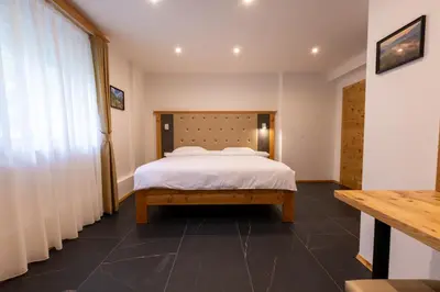 a bedroom with a bed with a wooden headboard at Apartments Viktor in Rateče