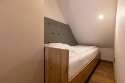 a small bedroom with a bed in a attic at Apartments Viktor in Rateče