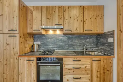 a kitchen with wooden cabinets and a sink at Apartments Viktor in Rateče