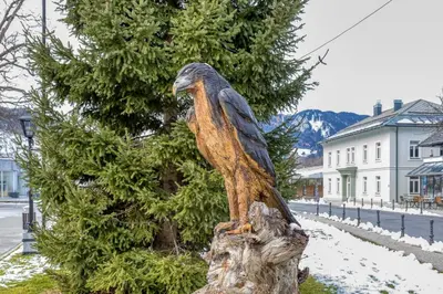 a statue of an eagle sitting on a tree stump at Apartments Viktor in Rateče