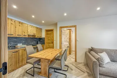 a kitchen and dining room with a wooden table and chairs at Apartments Viktor in Rateče